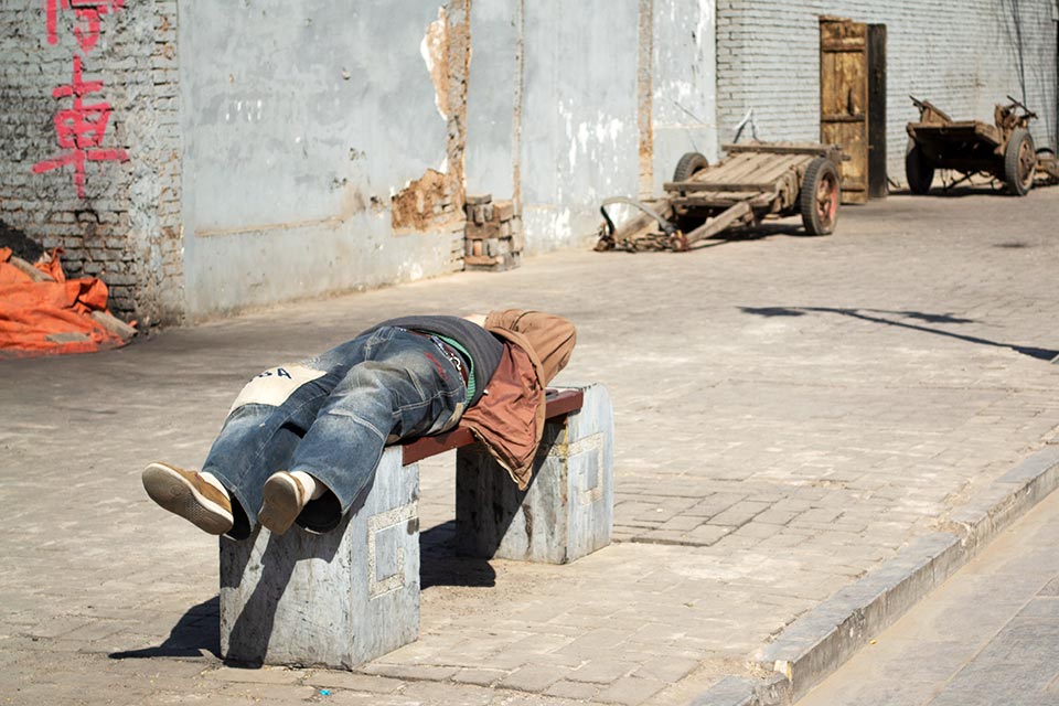 man asleep on bench in Pingyao